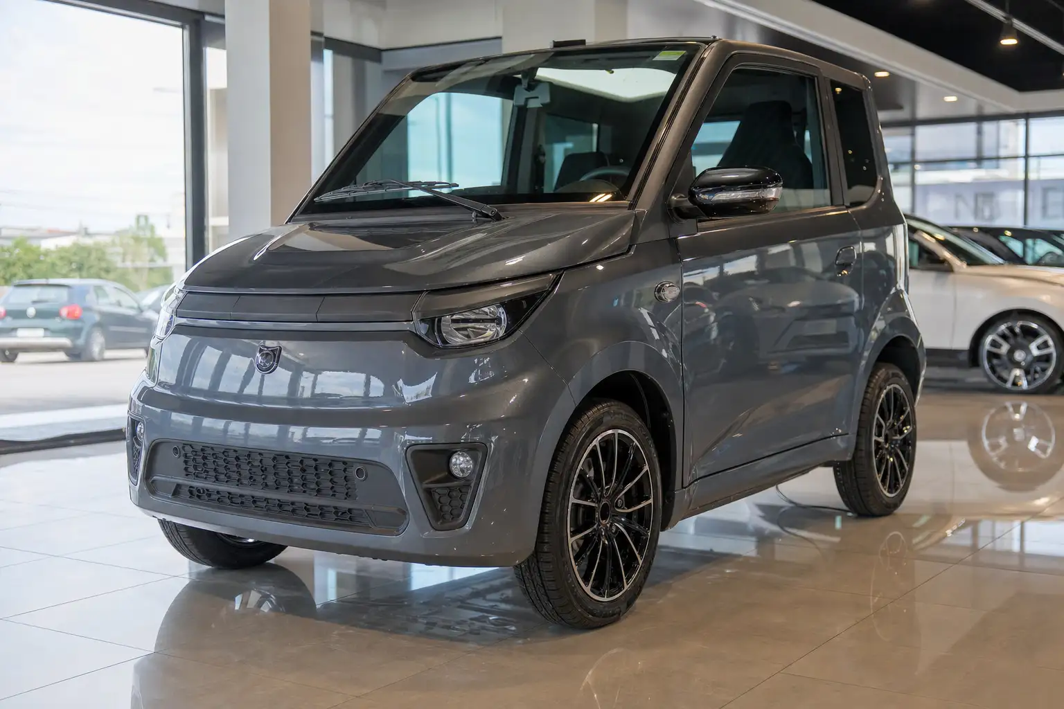 Voiture sans permis neuve garée devant un pavillon, carrosserie brillante inspectée par son propriétaire