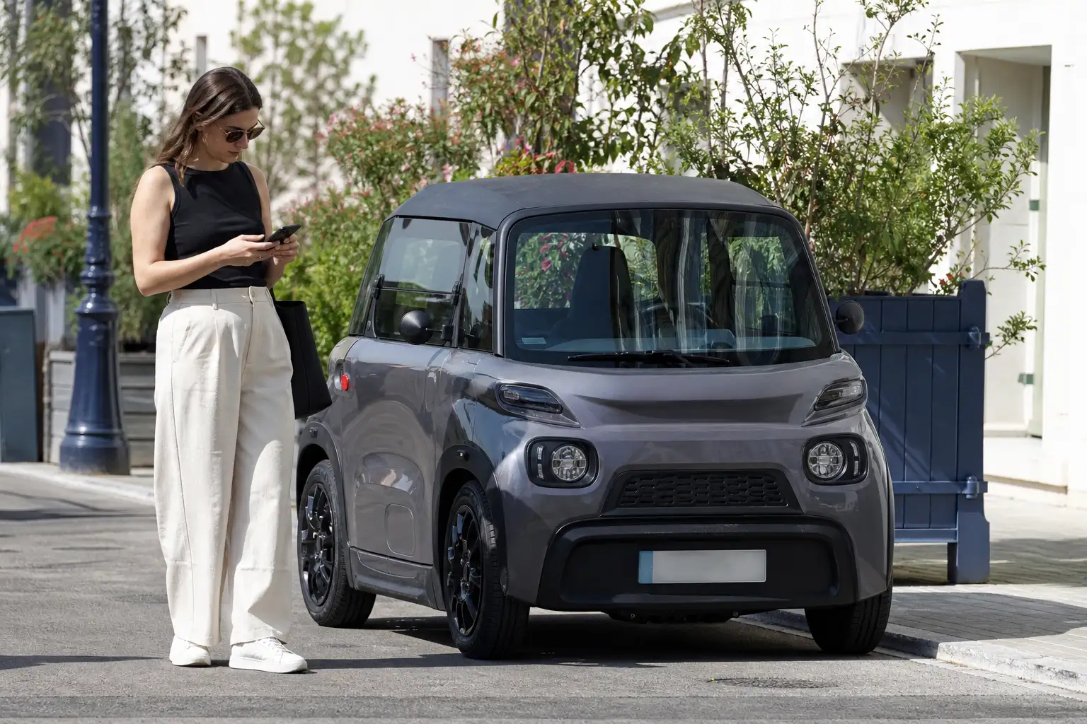 Personne consultant sur son smartphone l'attestation d'assurance de sa voiture sans permis, véhicule garé en arrière-plan