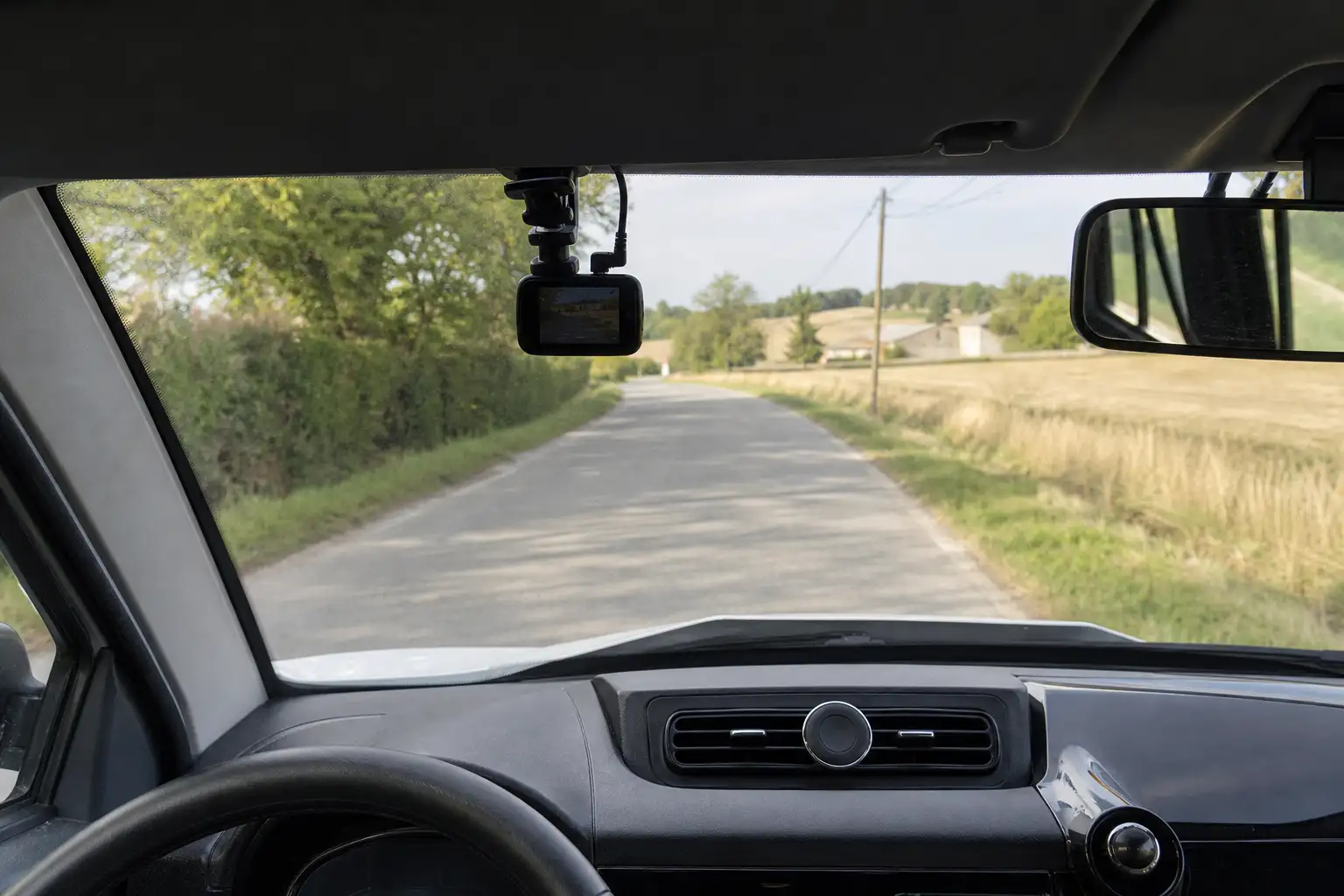 Petite caméra embarquée fixée sur le pare-brise d'une voiture sans permis, vue de l'habitacle vers la route