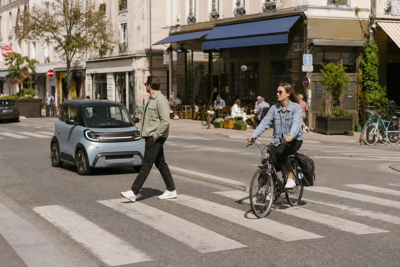 Passage piéton en centre-ville français, voiture sans permis arrêtée au feu rouge, piétons traversant en toute sécurité