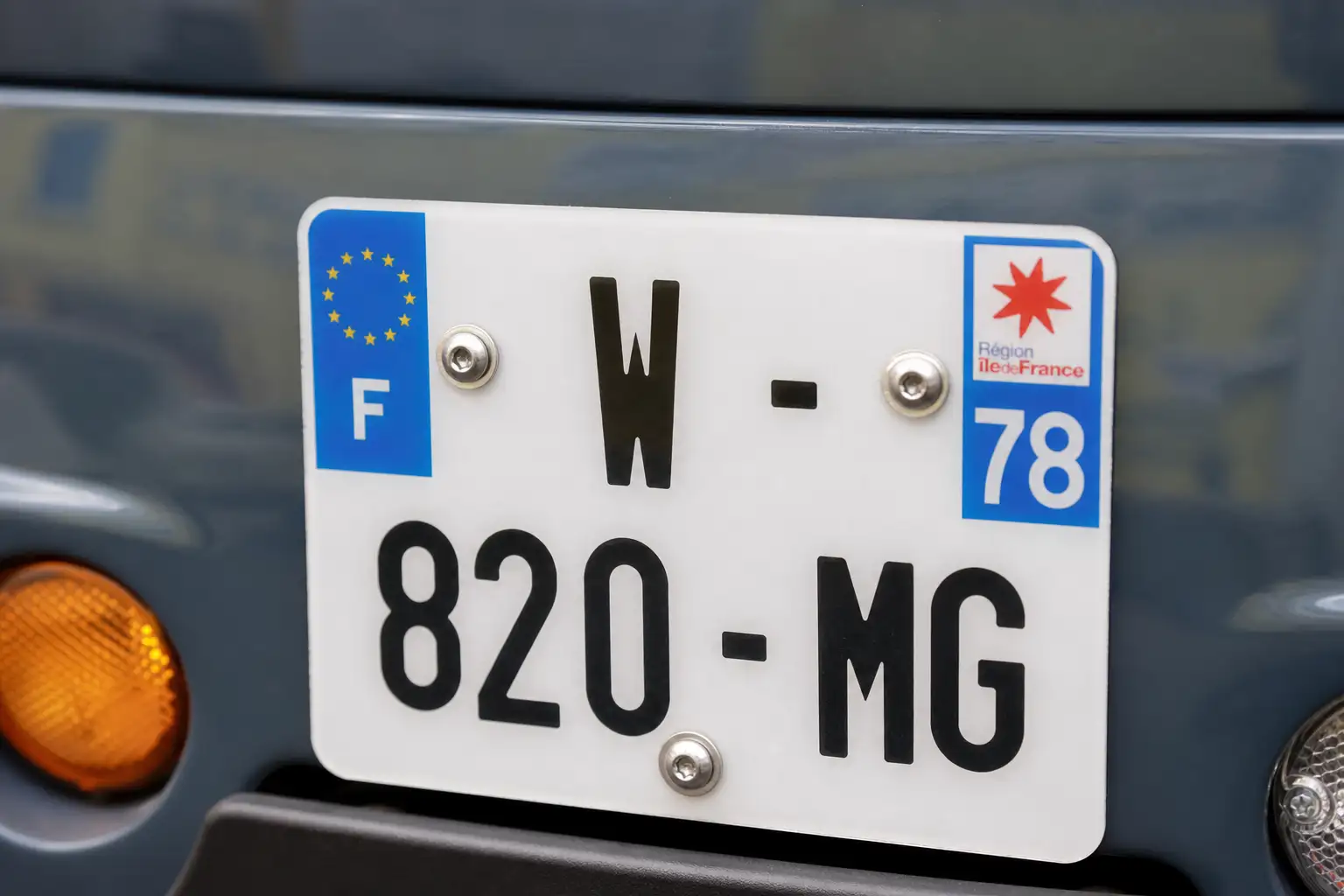Plaque d'immatriculation d'une voiture sans permis en gros plan, lumière naturelle, carrosserie moderne floue en arrière-plan